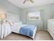 Serene bedroom with white furniture, light blue walls, and wood floors at 5936 Driftwood Ave # 16, Sarasota, FL 34231