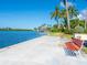 Scenic waterfront pathway with red benches and palm trees at 5936 Driftwood Ave # 16, Sarasota, FL 34231