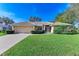 Tan house with attached garage and manicured lawn at 601 Lakescene Dr, Venice, FL 34293