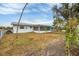 Backyard view with large tree and partial home view at 6045 Slade Rd, North Port, FL 34287