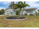 Ranch-style home with palm trees and a landscaped circular garden at 6045 Slade Rd, North Port, FL 34287