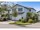 Two-story house with white double garage and lush landscaping at 6299 Crested Eagle Ln, Nokomis, FL 34275