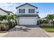 Two-story house with white garage door and landscaped yard at 6299 Crested Eagle Ln, Nokomis, FL 34275