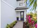 Front door entrance with brick walkway and colorful plants at 6299 Crested Eagle Ln, Nokomis, FL 34275