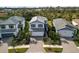 Two-story light blue house with gray roof and paver driveway at 6299 Crested Eagle Ln, Nokomis, FL 34275