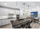 Modern kitchen with white cabinets, island, and dining area at 6299 Crested Eagle Ln, Nokomis, FL 34275