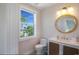 Modern bathroom with a round mirror, and a white vanity at 630 Companion Way, Longboat Key, FL 34228