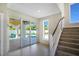 Modern staircase with glass doors leading to a patio and pool at 630 Companion Way, Longboat Key, FL 34228