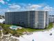 Aerial view of beachfront condo building with pool and beach access at 6300 Midnight Pass Rd # 810, Sarasota, FL 34242