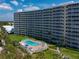 Aerial view of beachfront condo building with pool and landscaped grounds at 6300 Midnight Pass Rd # 810, Sarasota, FL 34242