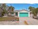 House exterior, turquoise garage, landscaped yard at 633 Avenida De Mayo, Sarasota, FL 34242