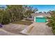 White house with teal garage door, landscaping, and driveway at 633 Avenida De Mayo, Sarasota, FL 34242