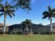 Home's rear elevation showcasing a screened lanai and lush lawn at 6442 Willowshire Way, Bradenton, FL 34212