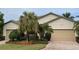 Two-car garage, beige house with landscaping, and a brick driveway at 6442 Willowshire Way, Bradenton, FL 34212