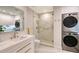 Laundry room with modern washer and dryer and marble shower at 655 Longboat Club Rd # 14A, Longboat Key, FL 34228