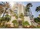 Stunning exterior of a modern beachfront condo building, surrounded by palm trees at 655 Longboat Club Rd # 14A, Longboat Key, FL 34228