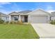 One-story home with gray siding, two-car garage, and landscaped lawn at 6708 162Nd E Pl, Parrish, FL 34219