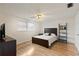 Well-lit bedroom with ceiling fan, wood flooring, and a ladder shelf at 680 Circlewood Dr # W3, Venice, FL 34293