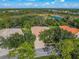 Property's aerial view shows a large house with a pool and a lush green landscape at 790 Shadow Bay Way, Osprey, FL 34229