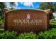 Brick entrance sign welcomes residents to Woodlands at Riverdell community at 790 Shadow Bay Way, Osprey, FL 34229