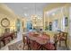 Bright dining room with a large chandelier and views into the living area at 790 Shadow Bay Way, Osprey, FL 34229