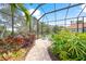 Relaxing screened patio with seating area and tropical plants at 790 Shadow Bay Way, Osprey, FL 34229