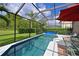 Screened pool area with patio furniture and a red umbrella at 8108 Haven Harbour Way, Bradenton, FL 34212