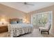 King sized bed, bay window, and ceiling fan in this serene main bedroom at 9499 Millbank Dr # 2721, Sarasota, FL 34238