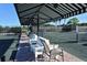 Tennis court with covered seating area and benches at 9499 Millbank Dr # 2721, Sarasota, FL 34238