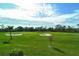 View of lush green golf course with sand traps and palm trees at 9621 Castle Point Dr # 1024, Sarasota, FL 34238