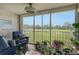 Sunroom with golf course view and abundant potted plants at 9621 Castle Point Dr # 1024, Sarasota, FL 34238