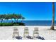 Scenic beachfront view with white Adirondack chairs at 307 Compass Point Dr # 101, Bradenton, FL 34209