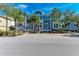 Two-story home with blue siding, metal roof, and palm trees at 307 Compass Point Dr # 101, Bradenton, FL 34209