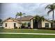 Single-story home with tile roof, landscaping, and palm trees at 1144 Hoover St, Nokomis, FL 34275