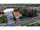 Aerial view of two houses with tile roofs, near a lake at 11816 Altamonte Ct, Venice, FL 34293