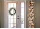 Front entry door with a charming wreath and sidelights at 11816 Altamonte Ct, Venice, FL 34293