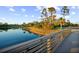 Wooden footbridge over calm lake water in a tranquil setting at 11816 Altamonte Ct, Venice, FL 34293