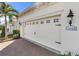 White two-car garage with decorative hardware and brick driveway at 11816 Altamonte Ct, Venice, FL 34293