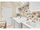 Laundry room with washer, dryer, sink, and floral wallpaper at 11816 Altamonte Ct, Venice, FL 34293