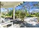 Relaxing covered porch with white rocking chairs, overlooking a landscaped yard at 11816 Altamonte Ct, Venice, FL 34293