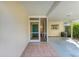 Inviting front entry with teal door, screened porch, and terracotta tile flooring at 1220 De Narvaez Ave, Bradenton, FL 34209