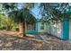 Side of the house showcasing teal walls and tropical landscaping at 1220 De Narvaez Ave, Bradenton, FL 34209