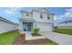 Two-story light blue house with a two-car garage and landscaping at 13014 Bayberry Way, Parrish, FL 34219