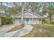 Charming one-story house with gray siding, a teal door, and a stone walkway at 1335 12Th St, Sarasota, FL 34236