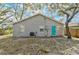 House back view shows gray siding, teal door, and a yard at 1335 12Th St, Sarasota, FL 34236