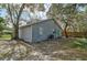 House back view shows gray siding, teal door, and a yard at 1335 12Th St, Sarasota, FL 34236