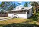 Charming single-story home showcasing a screened-in porch, steps, well-maintained lawn, and mature trees at 1717 32Nd St, Sarasota, FL 34234