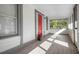 Inviting front porch features a red door and tile flooring at 1717 32Nd St, Sarasota, FL 34234