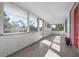 Bright and airy screened porch with tile flooring and a red front door at 1717 32Nd St, Sarasota, FL 34234