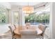 Elegant dining room featuring a round table and chandelier, overlooking the pool at 1810 Wisteria St, Sarasota, FL 34239